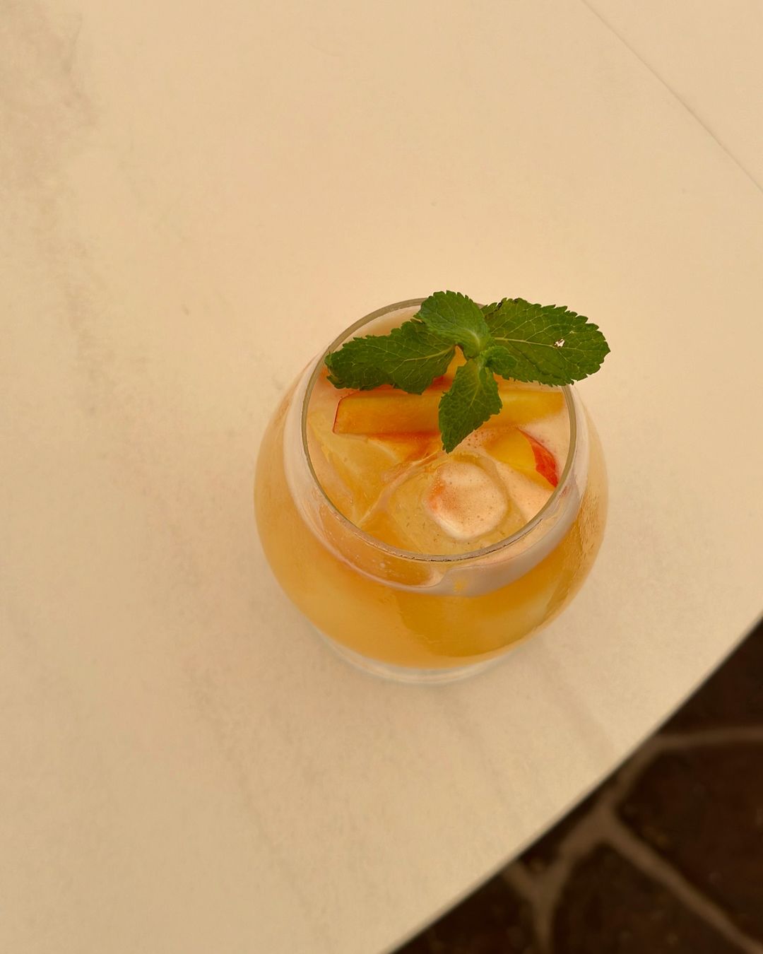 Cassis Lemonade in a glass with a mint leaf as decoration.