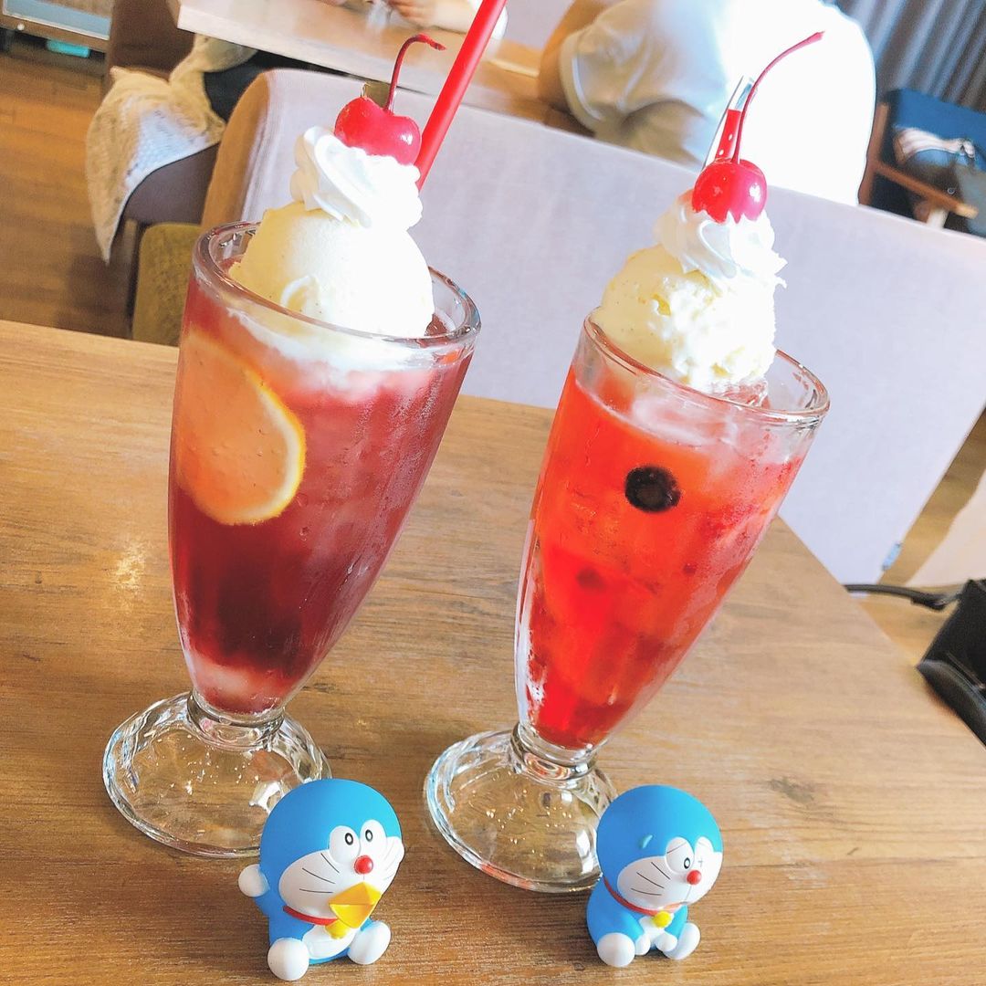 Two glasses of ice cream with a cherry on top, a cool and delightful dessert.