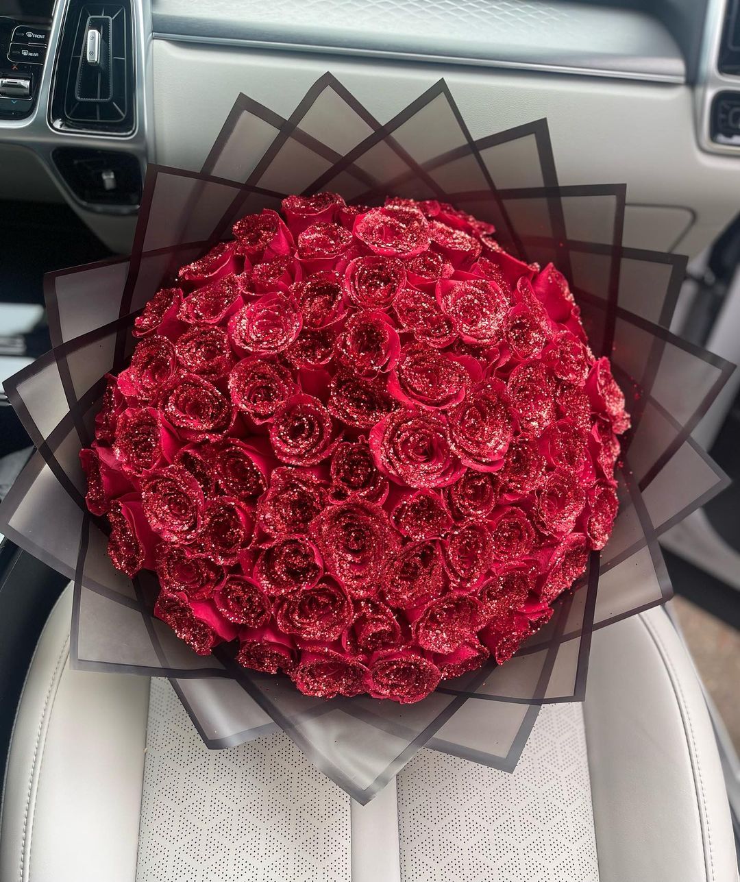 A vibrant bouquet of red roses elegantly placed on a car seat, showcasing their beauty and charm in a unique setting.